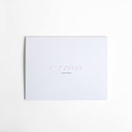 White greeting card with “I Am Sorry” embossed in soft pink Braille, paired with a white envelope. Elegant, handmade card crafted with precision and care.