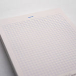 Modern pink notepad with graphic blue grid and notes heading – 100-page stationery. (front view)