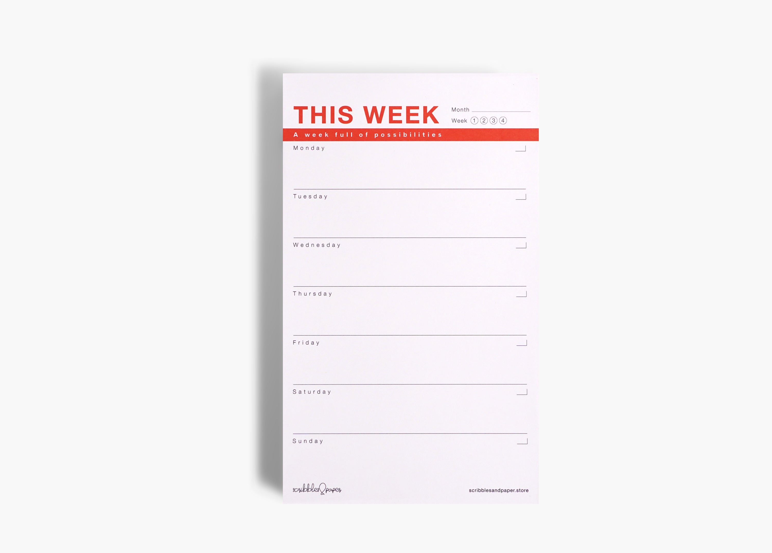 Large designer notepad with light pink background and red lettering, showing a weekly layout on smooth premium paper.